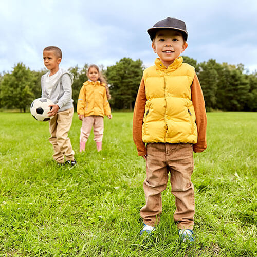草むらで遊ぶ笑顔の少年少女